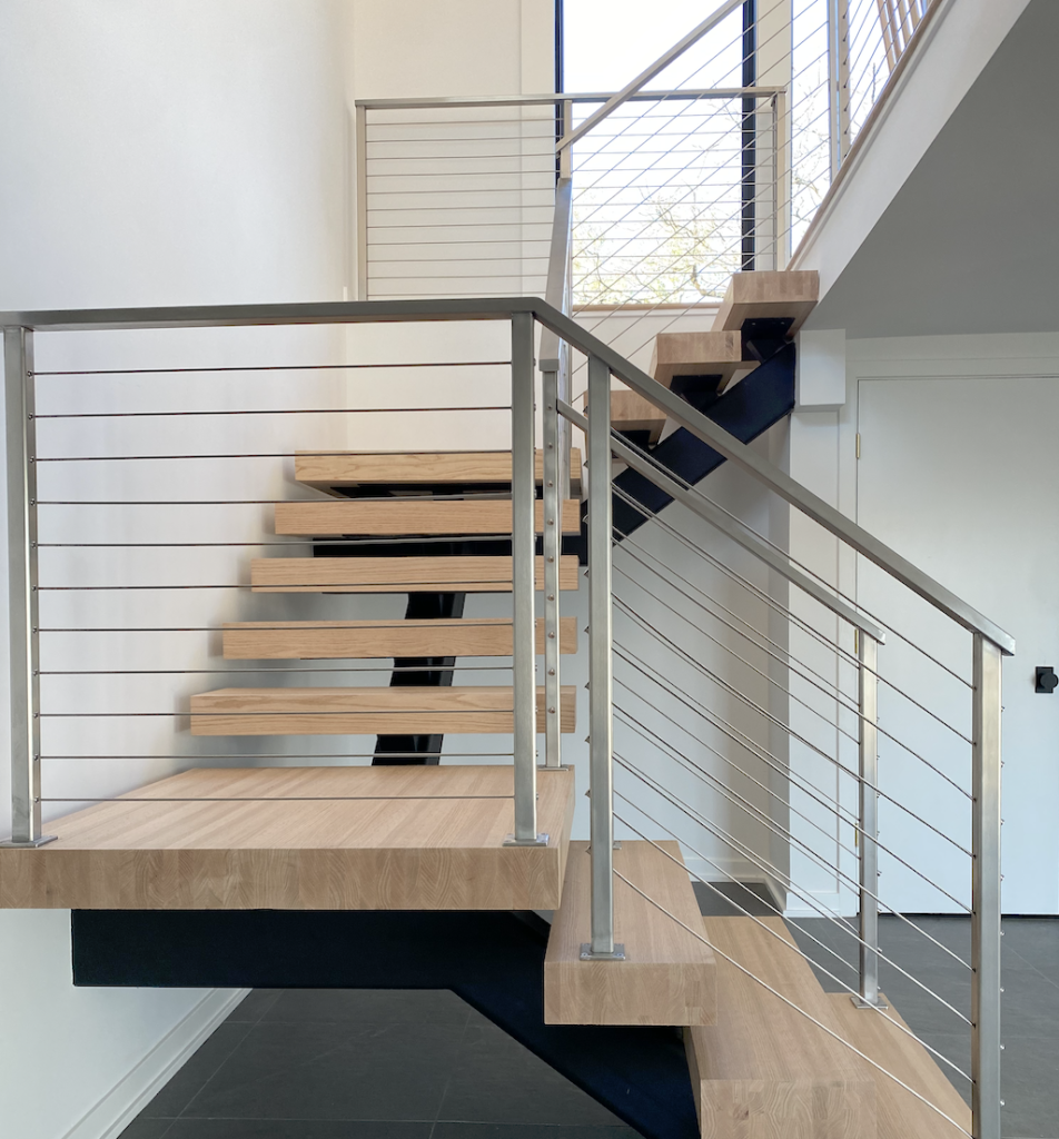 Modern floating stairs in a greenwich Connecticut ranch home with stainless steel cables railing system.